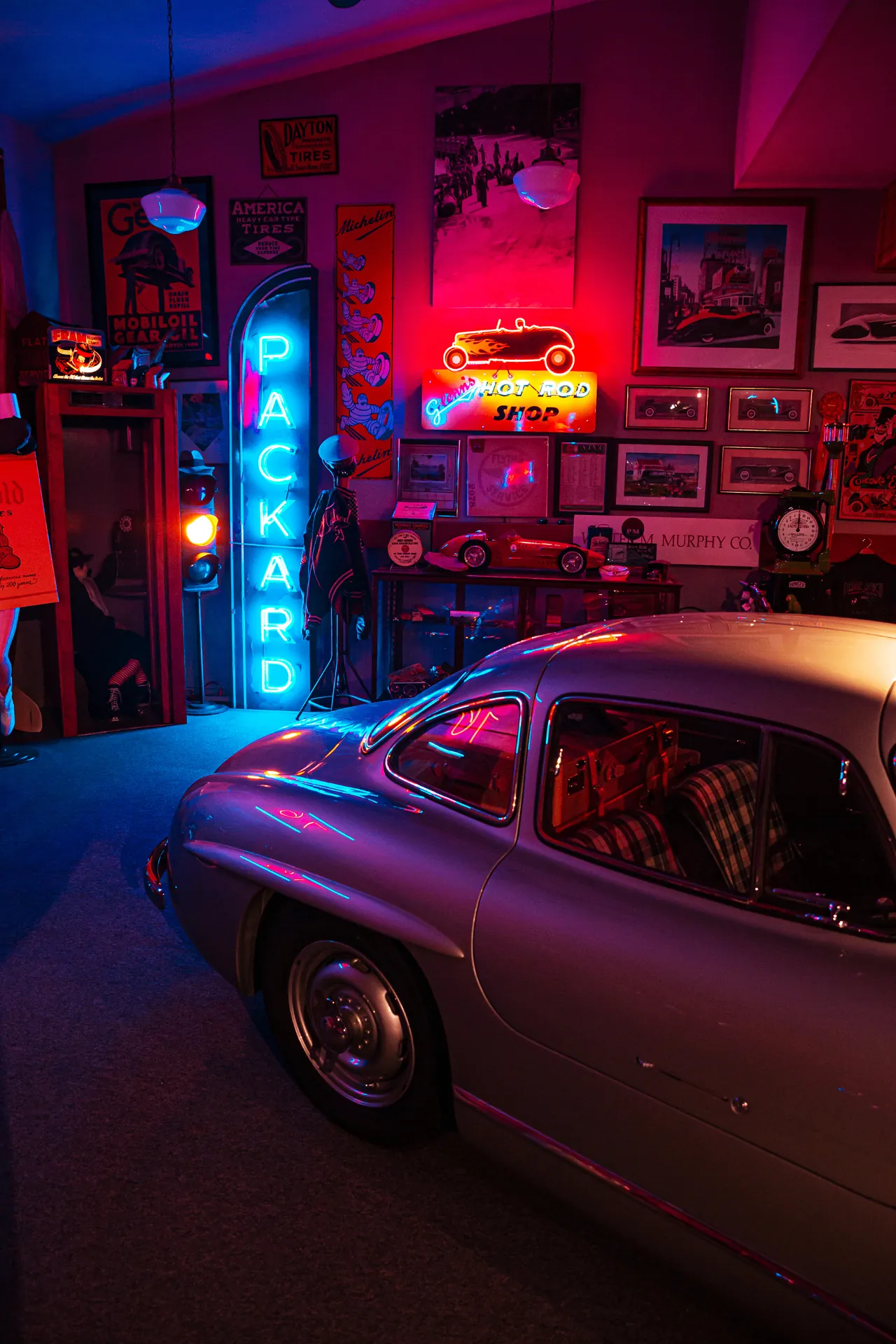 Interior of Glenn's Hot Rod Shop with a classic hot rod under work lights and vintage tools.